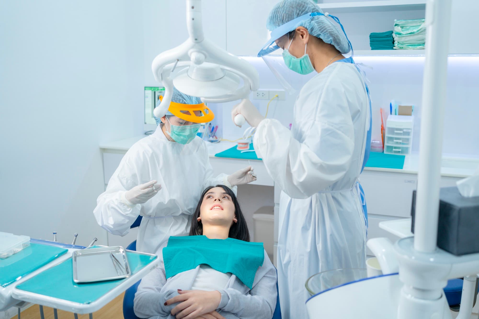 Paciente en el sillón dental durante una valoración con dos odontólogos